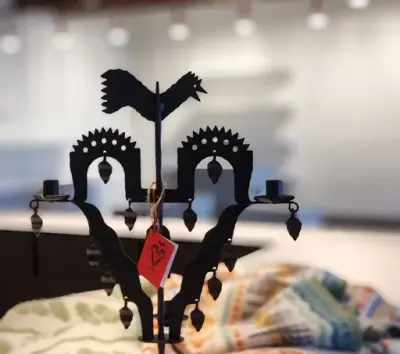 En klassisk, svart smidesljustake i butikens sortiment