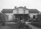 Sällskap framför hus vid Norrsundet. (Bilden ingår i ett fotoalbum med titeln Norrsundet).