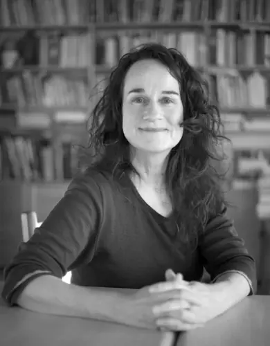 Dame i svart-kvit i bibliotek med hendene folda