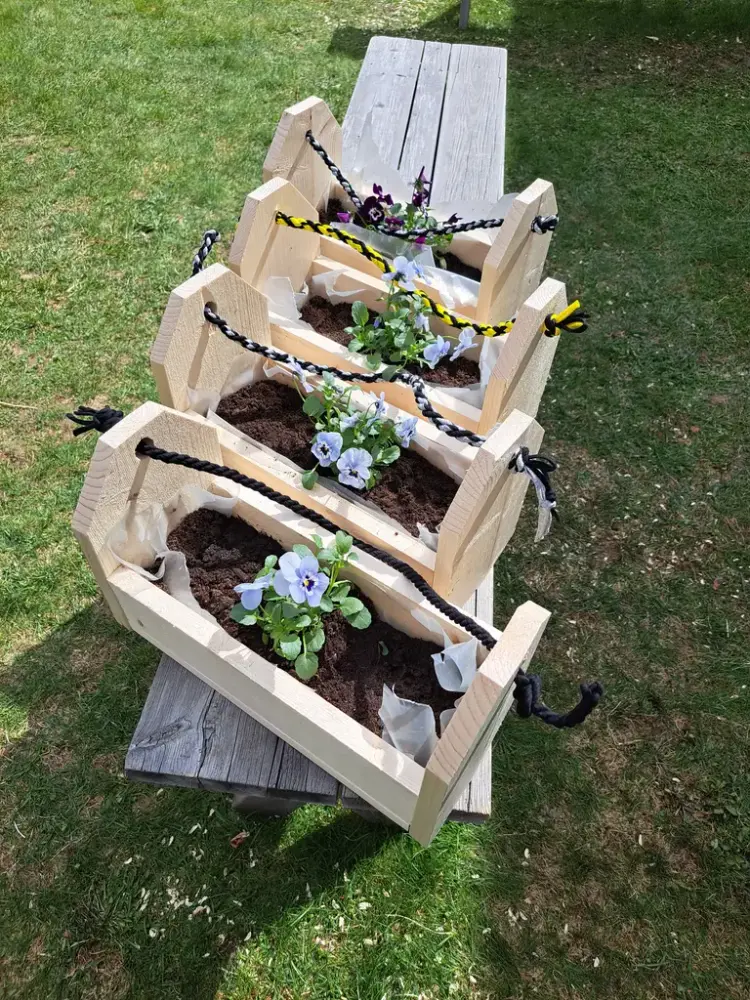 Fire ferdige såkasser med blomster i. 