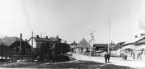Vy över Oxtorgsgatan och Kvarngatan i stadsdelen Väster, Söderhamn. Till vänster Garnbutiken i f.d. gevärsfaktoriets borrhus, numera Söderhamns stadsmuseum. Foto från omkring 1900 - 1910.