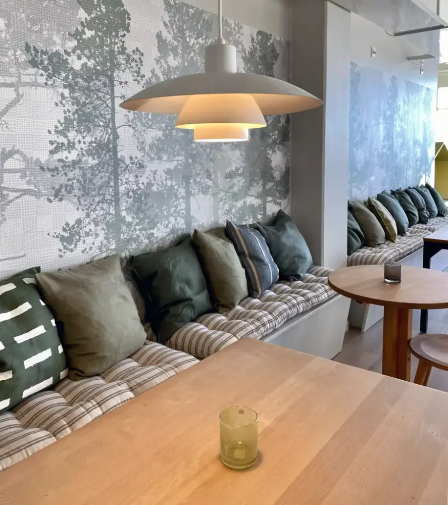 Soffor och kuddar klädda i gröna tyger i museets kafélokal.