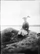Flicka och hund sitter på klippa, Uppland
