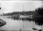 Tre män sitter i en segelbåt och metar, Uppland