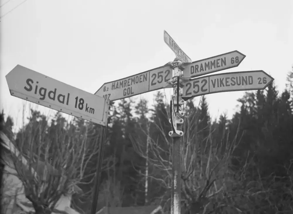 Vegskilt på Krøderen i 1943. Skiltene viser avstand til Sigdal, Vikersund, Drammen, Hamremoen og Gol
