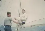 Lars Thörn (stående) och Hans Stendahl (sittandes i segel) ombord HAZARD III, troligtvis under försök att segla in yawlens svenska bomullssegel i Brenton Cove inför Newport Bermuda Race 1954. Amerikanska segel i dacron levererades senare och användes istället under kapseglingen.
