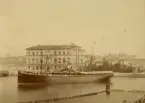 Passagerarångfartyget AEOLUS ligger förtöjd vid Museikajen mellan Blaseiholmen och Skeppsholmen. Fartygets babordssida är vänd mot kameran och i bakgrunden syns nationalmuseum samt omgivande byggnader.
