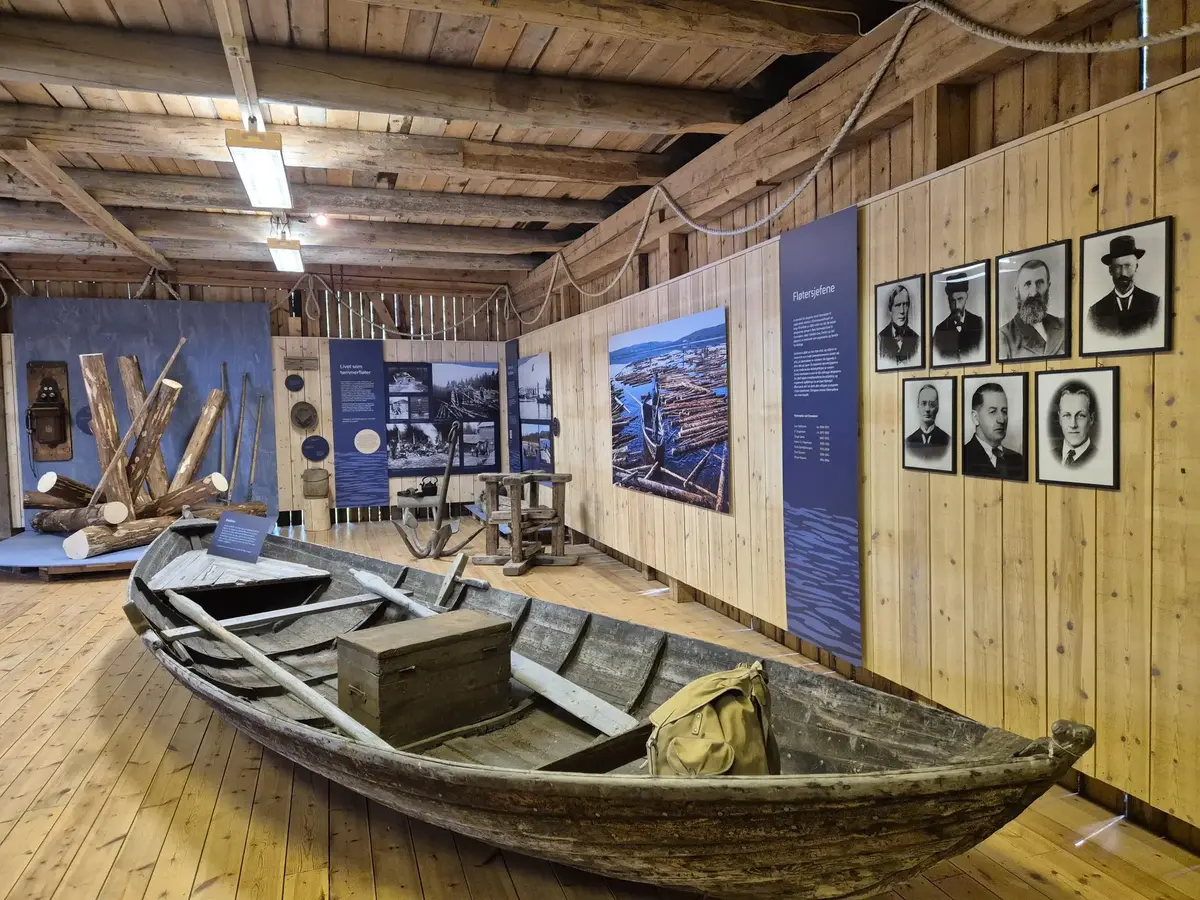 En tømmerfløterbåt plassert på gulvet i en utstilling om tømmerfløting 