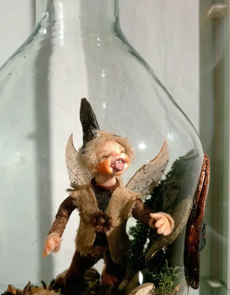 En liten alvefigur i glasskrukke, alven er laget av naturmaterialer.