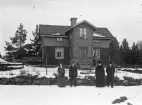 Fyra personer framför ett bostadshus.