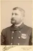 Porträtt av troligen en uniformerad polis eller tjänsteman.
