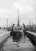 Slussens södra port öppnas och ångfartyget WISBY stävar ut i Saltsjön. Året är 1905.