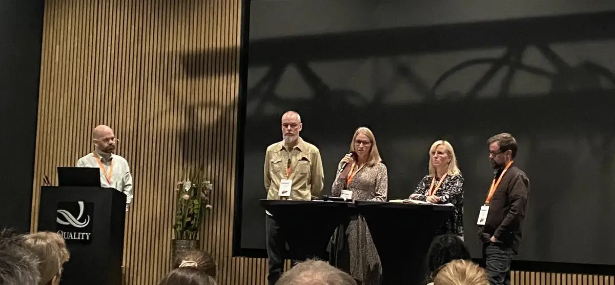 Ordstyrer leder panelsamtale bestående av fire deltakere