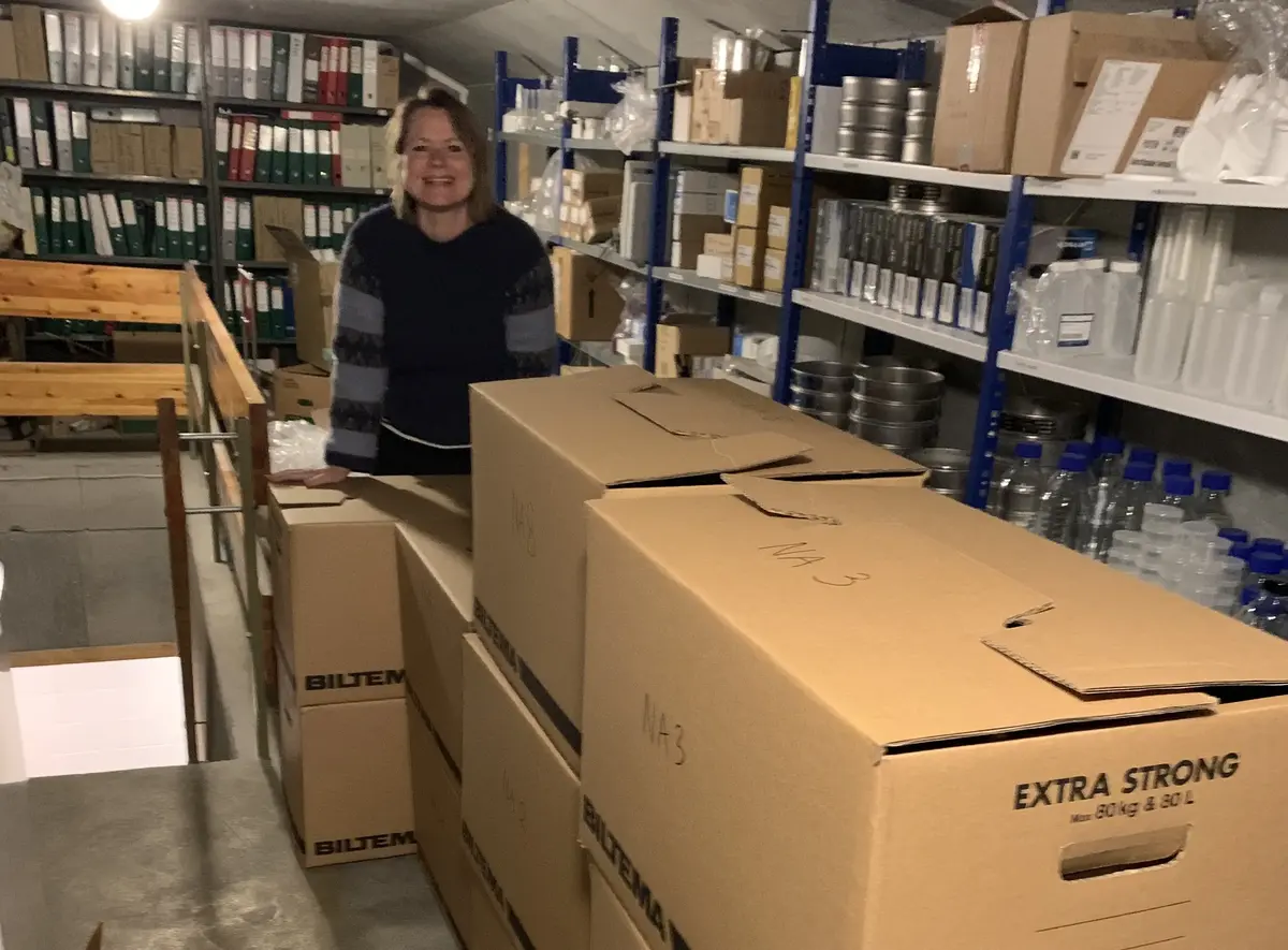 Kvinne i arkivrom med flytteesker