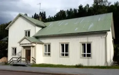 En vit byggnad med ljusgrönfärgat tak.