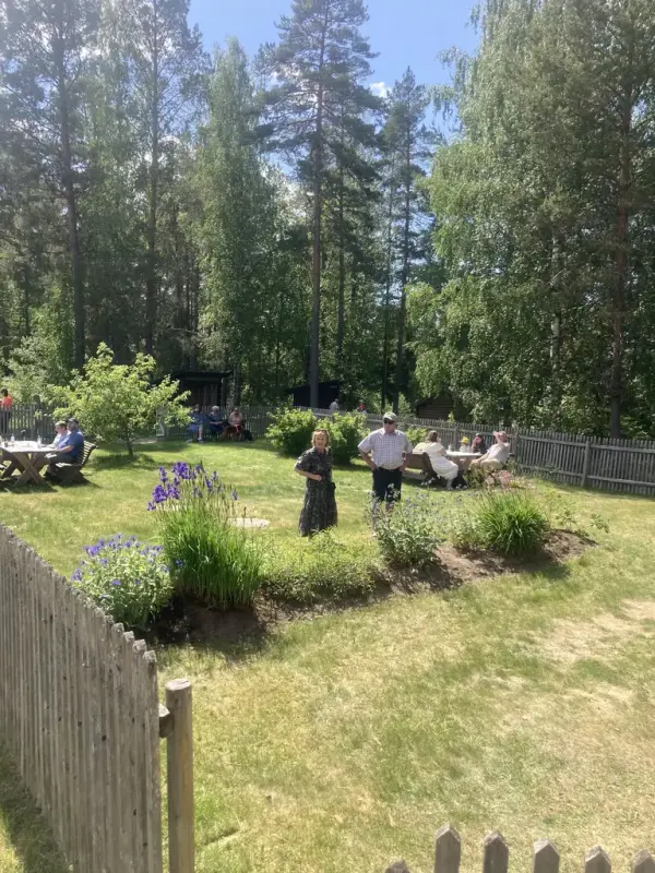 Mennesker koser seg i en hage på sommeren