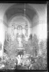 Ett brudpar i en kyrka med dekorerad med björkar.
