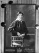 Visitkort monterat för reprofotografering. I detta fall av bygdefotografen A C Hultgren i Svinhult. Som avbildad sitter Anna Hultgren från Sörgården i Fundshult. Hon var född i socknen 1891 och gift 1917 med Josef André i Flinstorp. Sorgligt nog fick hon ett kort liv. Avliden redan 1922 i sviterna av tuberkulos under behandling i Vadstena. Möjligtvis förklarar det beställningen av reprofotografiet.

Kommentar:
Repro av visitkort efter original av hovfotograf Rylander, Eksjö.