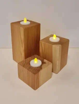 3 telysholderer i tre i ulike høyder. Foto.