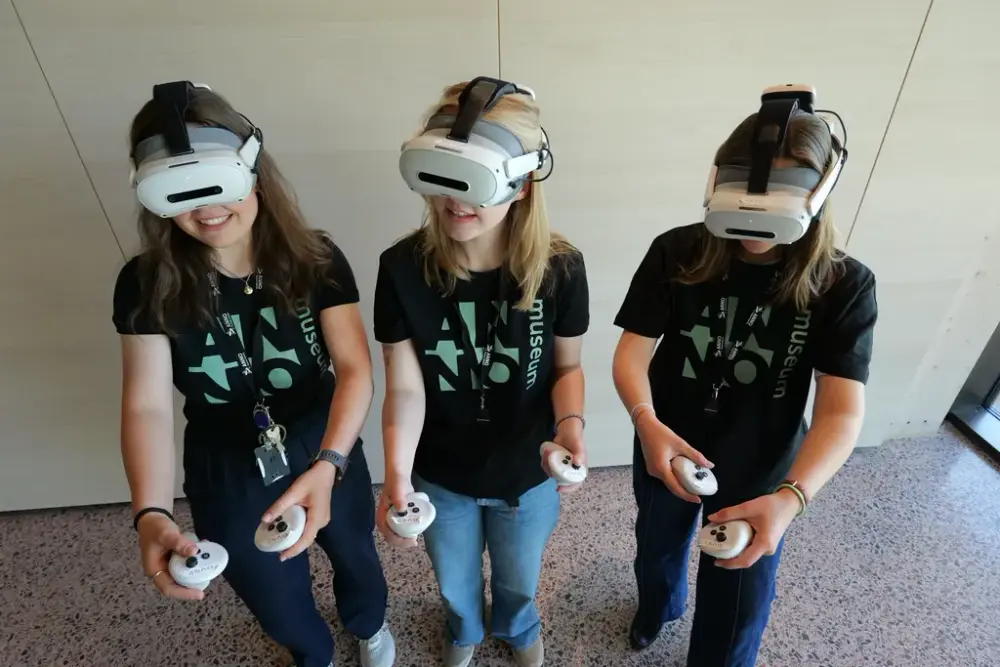 Tre jenter med VR-briller og håndkontrollere