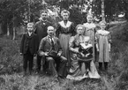 Familjen Andersson i Idhult samlade för fotografering omkring 1907. Vid makarna Konrad och hustrun Karolina Andersson ses barnen Sigurd, Ernst, Ester, Judit och Gerda. I Karolinas knä sitter parets yngsta barn, sonen John. Foto omkring 1907.