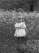 Maria, porträtterad knappt tre år fyllda invid hemmet i Fundshult. Dotter till Arvid och Nanny Hultgren i byns södergård. Sommaren 1923.