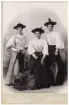 Kabinettfoto över 3 unga damer iklädda hattar och paraplyer m. m. Systrarna Olsson, sömmerskor.