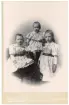 Kabinettfoto över 3 barn i matchande kläder troligen familjefoto.