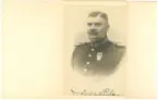 Porträtt fotografi i kuvert föreställande J. M. Liden i uniform.