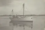 Fiskebåt på havet med strand vid horisonten.