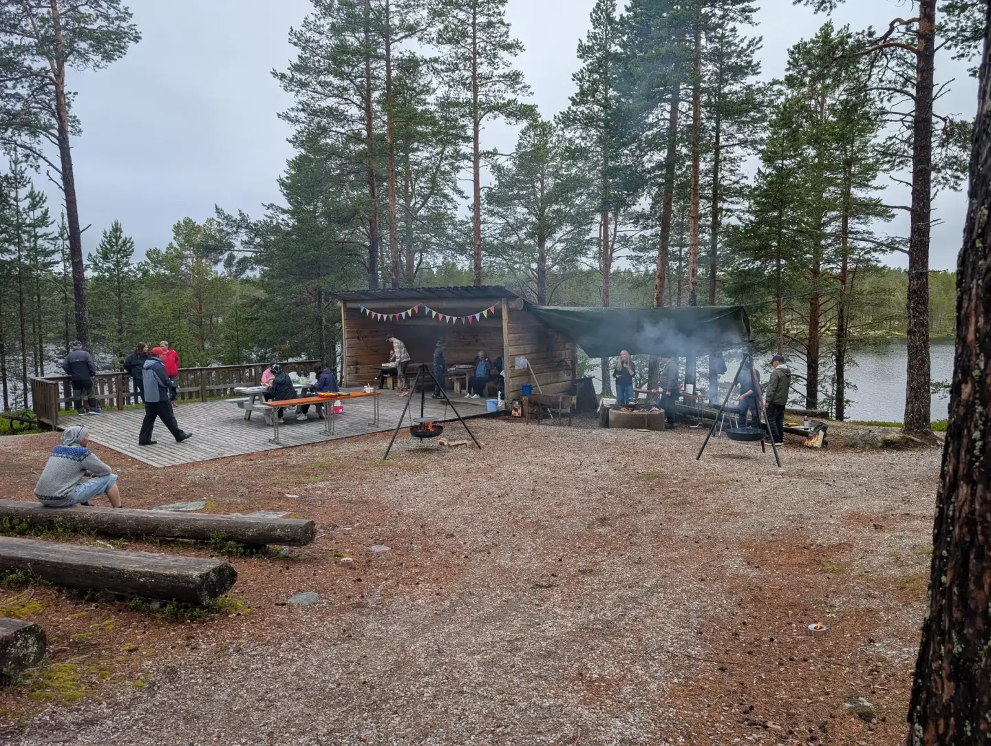 Bilde av festplassen på blokkodden. Gapahuken er pyntet med flagg, ute på plassen står det 2 bålpanner og det flere folk som går rundt. 