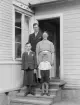 På farstutrappan till hemmet i Idhult ses makarna Sigurd och Gertrud Andersson med sina två söner Allix och Birger. Foto omkring 1940.