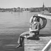 En flottist vid Stockholms örlogsstation tar vilopaus och solar på en brygga på Skeppsholmen.