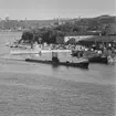 Ubåt, sannolikt den brittiska HMS ARTEMIS (P449) på flottbesök, passerar Stockholms örlogsvarv. I bakgrunden bl a jagaren VISBY (J 11).