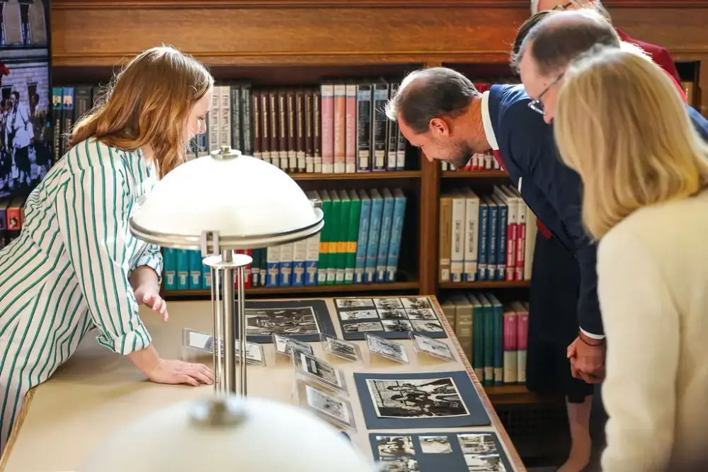 The Crown Prince studying the photographs and film from Campbell Norsgaard who served as the official photographer and filmmaker for the Royal Norwegian Air Force in-exile in Canada. Many of the photos and films show the current King of Norway with his family.