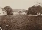 Gårdsvy från Haraldsmåla gård. På huvudbyggnadens trappa står en flicka och en pojke.
På baksidan av det monterade fotografiet står noteringen 
