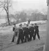 Manskap ur flottan bär en kista svept i örlogsflaggan till en begravningsceremoni i Skeppsholmskyrkan.