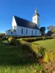 Hälsingtuna kyrka sedd från nordöst, till höger skymtar sockenstugan.