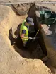 En arkeolog i en djup grop som påträffades i samband med en arkeologisk undersökning vid Juneporten i centrala Jönköping.