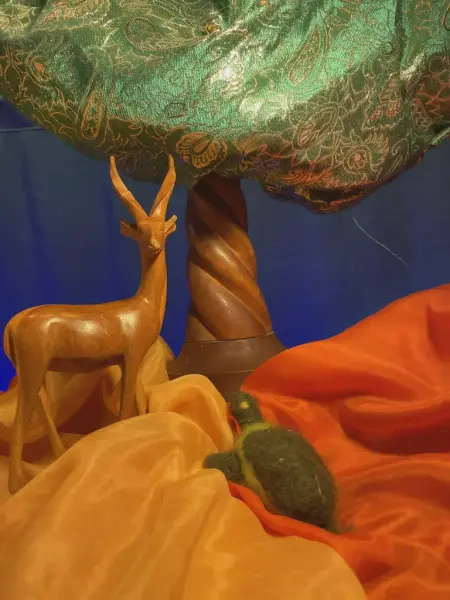 Et tre, en antilope og en skilpadde i et landskap lags av tekstiler. 