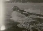 Spetsgattad motorbåt plöjer genom vågorna.