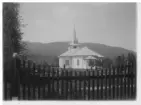 Dalby kyrka och kyrkogård bakom ett staket.