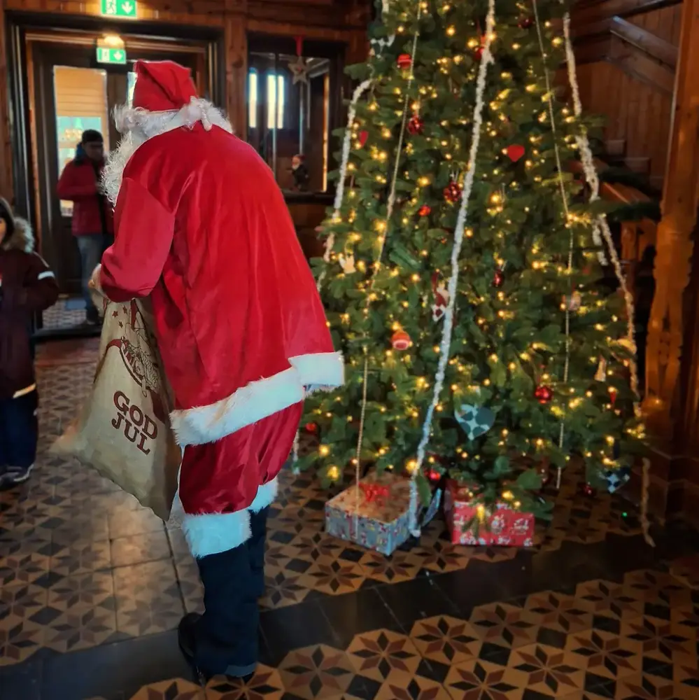 Juletre og rødkledd nisse med gavesekk i Hallen på Villa Fridheim
