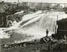 Byggandet av Älvkarleby kraftverk med en man som står och fiskar vid älven, omkring år 1906 (enligt text i album).