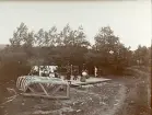 Byggandet av timmerränna, med flera personer närvarande, omkring år 1906 (enligt text i album).