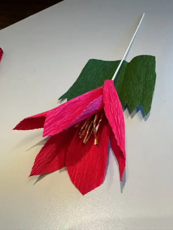 Her lages en rosa papirblomst. Her har kronbladene kommet på, og det grønne begerbladene skal festes. 