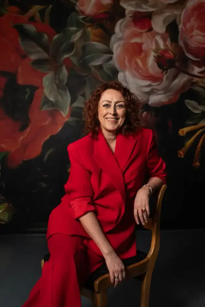 Portrett av folkesanger og musiker Camilla Granlien, kledt i en knallrød dress.