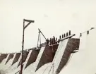 Byggandet av Älvkarleby kraftverk med arbetare uppe på den stora timmer- och stenkistan, omkring 1906 (enligt text i album).