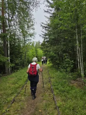 Mennesker går langs sti i skogen på gamle jernbanespor