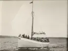 Segelskuta med motor, många passagerare.